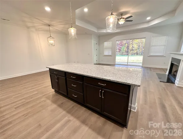 a spacious bathroom with a granite countertop sink a toilet a mirror and shower