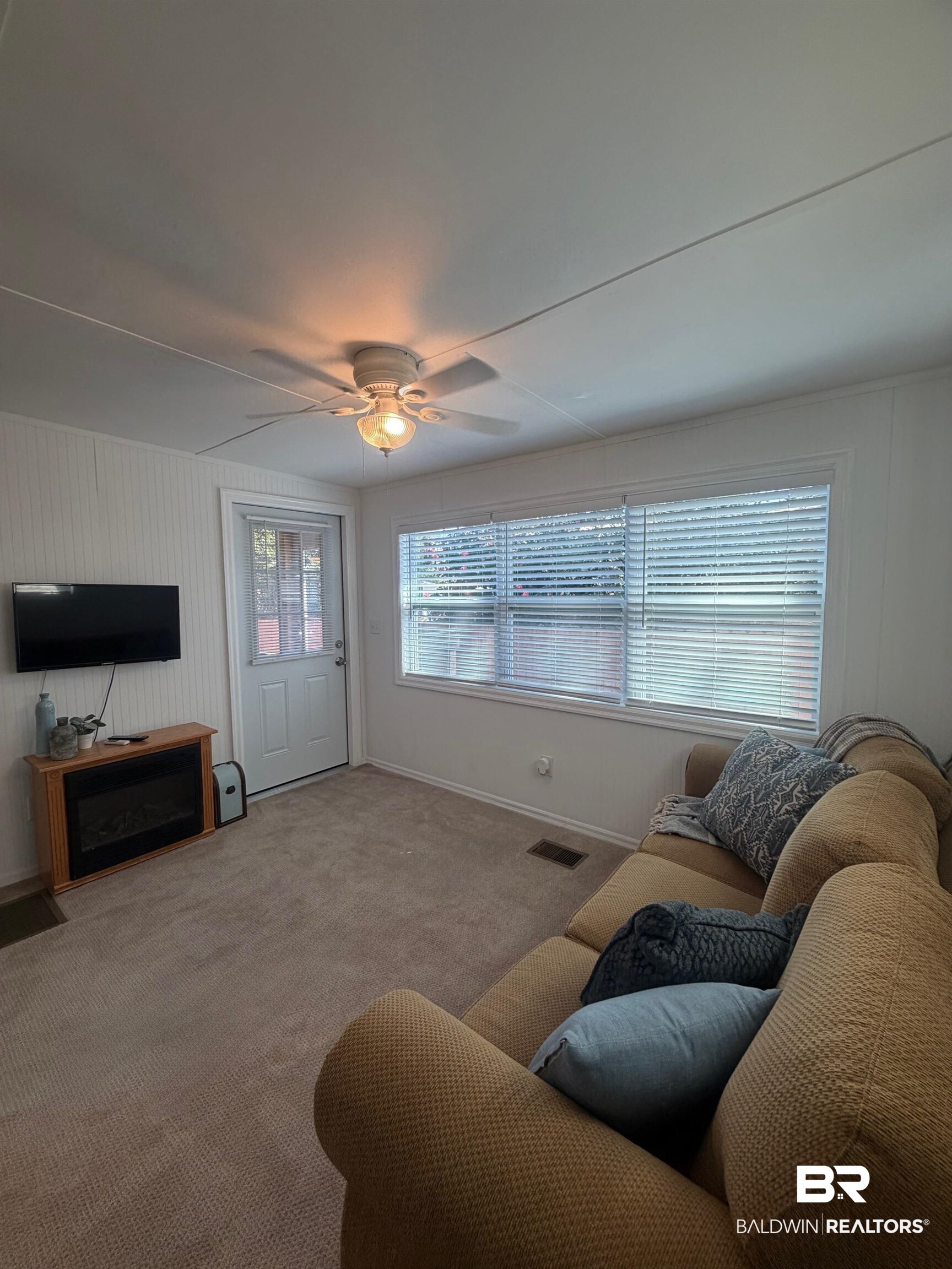 685 Escambia Loop Lillian, AL 36549 - Photo 16 of 43 Living room with ceiling fan, carpet flooring, and a fireplace