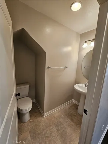 a bathroom with a granite countertop toilet and a sink