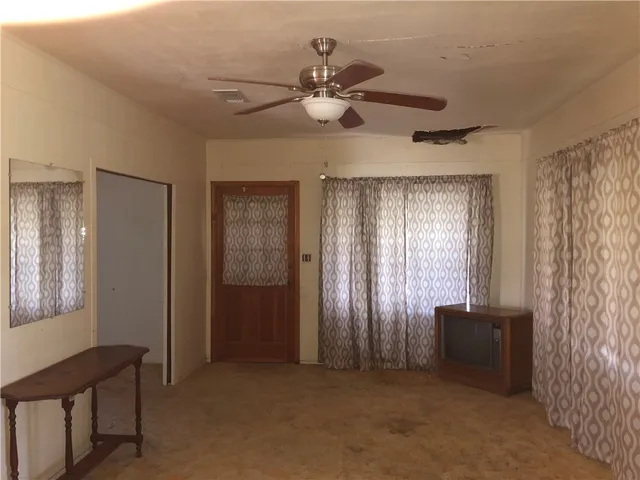 a view of a livingroom with a ceiling fan and window