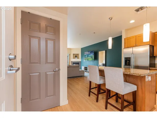 a living room with furniture a flat screen tv and kitchen view