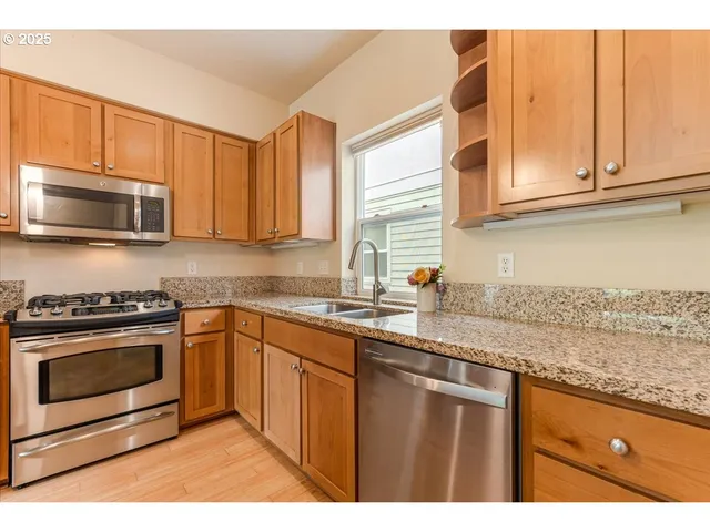 a kitchen with stainless steel appliances granite countertop a sink stove and microwave