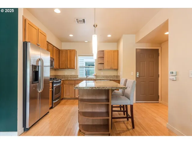 a kitchen with a refrigerator a sink dishwasher with a dining table and chairs