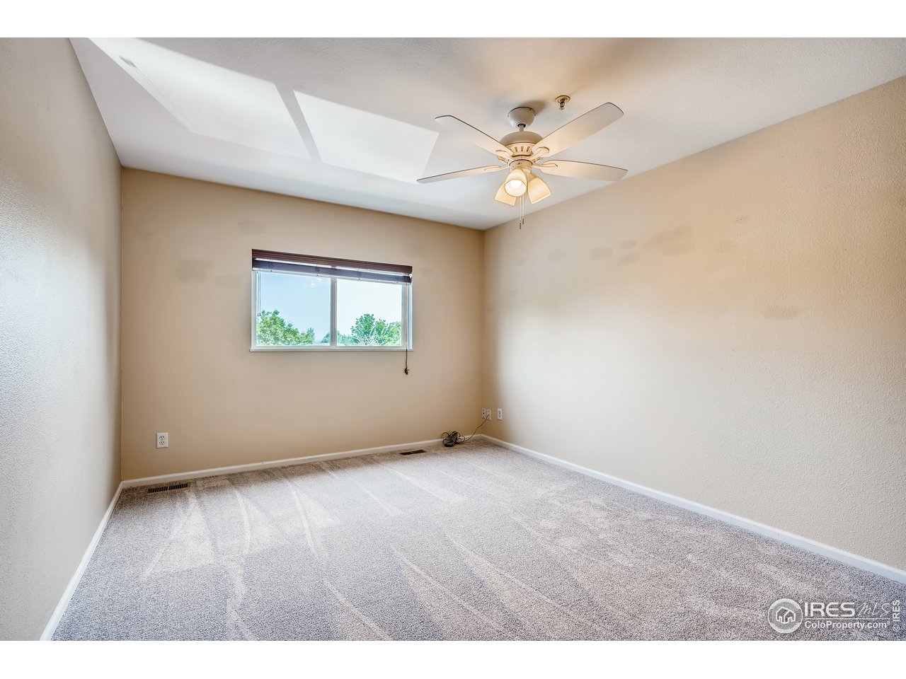 2702 Rigden Parkway, Unit A3 Fort Collins, CO 80525 - Photo 14 of 33 an empty room with wooden floor fan and windows