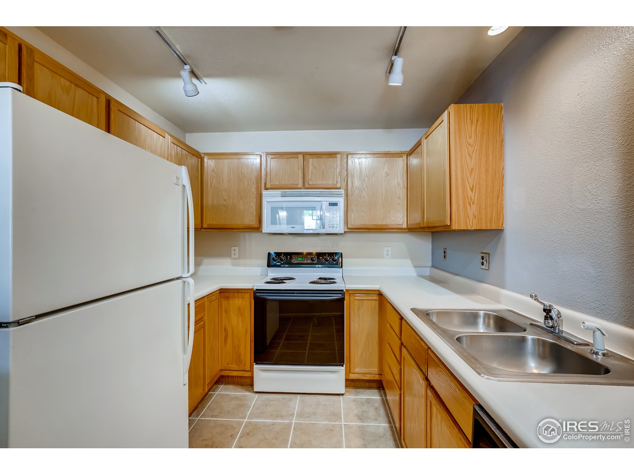 2702 Rigden Parkway, Unit A3 Fort Collins, CO 80525 - Photo 10 of 33 a kitchen with stainless steel appliances granite countertop a sink a stove and a refrigerator with wooden floor