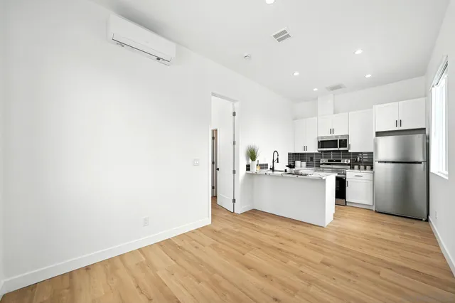 a kitchen with wooden floors and white appliances