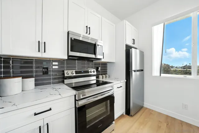 a kitchen with appliances a sink and cabinets