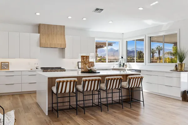 a kitchen with a dining table chairs and refrigerator