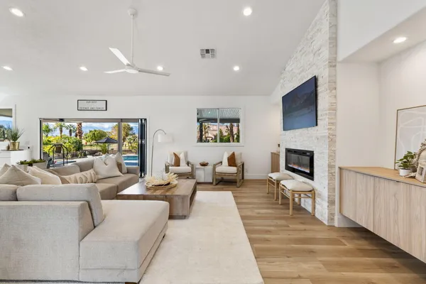 a kitchen with stainless steel appliances granite countertop a stove top oven a sink dishwasher and a refrigerator with wooden floor