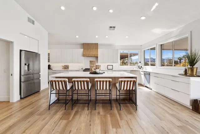a kitchen with stainless steel appliances a table and chairs in it