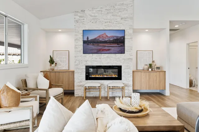 a living room with furniture a mirror and a wooden floor