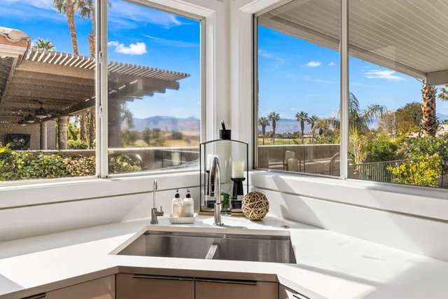 a bathroom with a toilet a sink a light fixture and a glass door shower