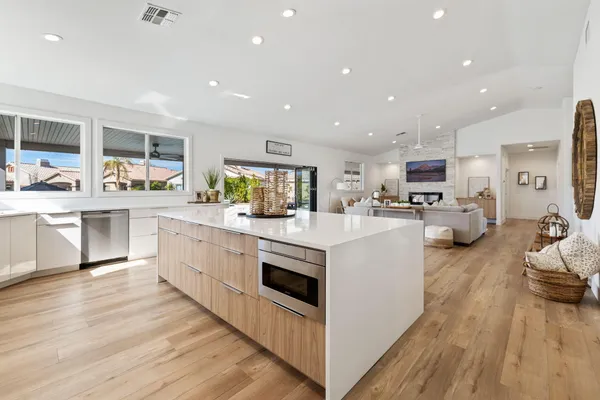 a living room with furniture kitchen view and a large window