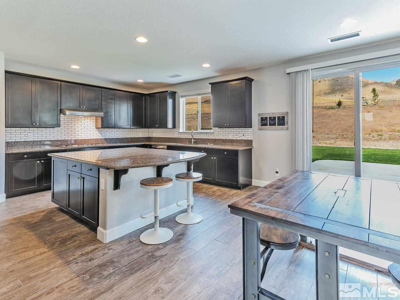 10140 Barrel Racer Drive Reno, NV 89521 - Photo 4 of 24 a kitchen with a table chairs a sink dishwasher stove and cabinets with wooden floor