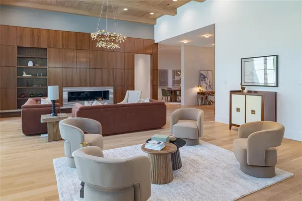 a living room with furniture a fireplace and a chandelier
