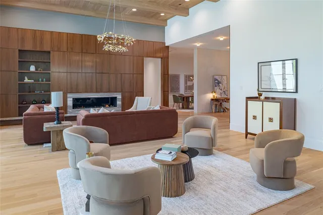 a living room with furniture a fireplace and a chandelier