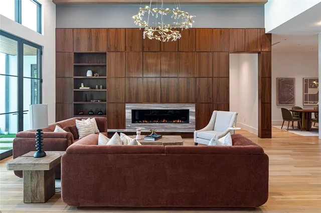 a living room with furniture a fireplace and a chandelier