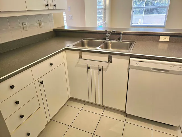 a view of a kitchen sink window and cabinets