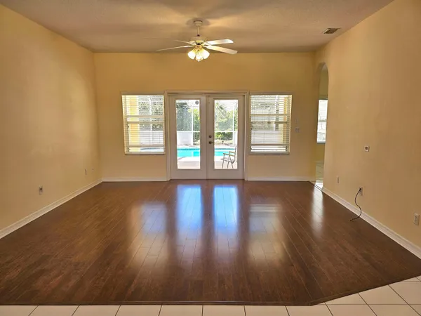 a view of an empty room with window and wooden floor