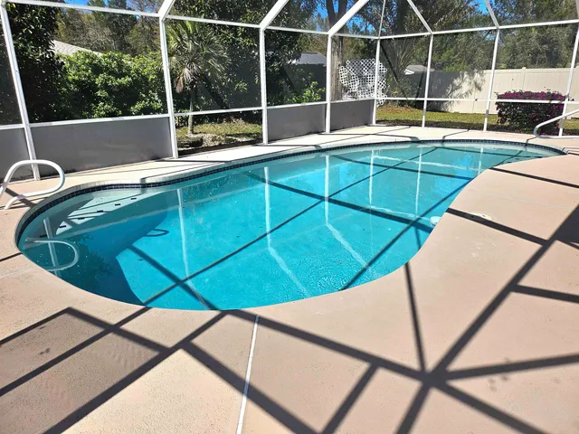 a view of a balcony with a swimming pool and sitting area