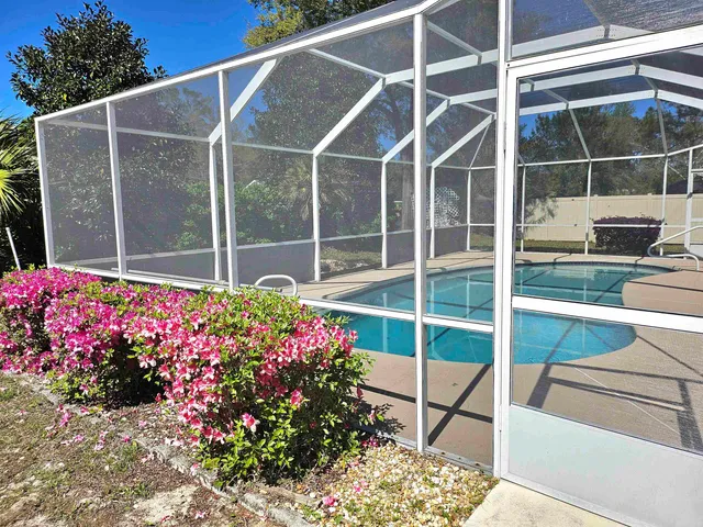 a view of a potted flower in the glass windows with flower garden