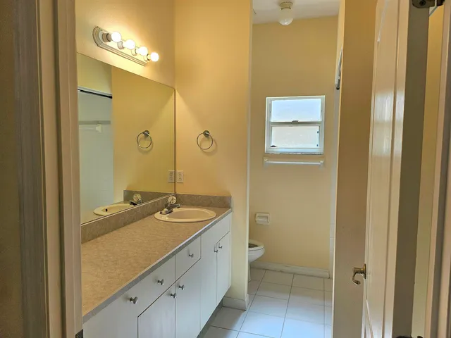 a bathroom with a granite countertop sink a mirror and a shower