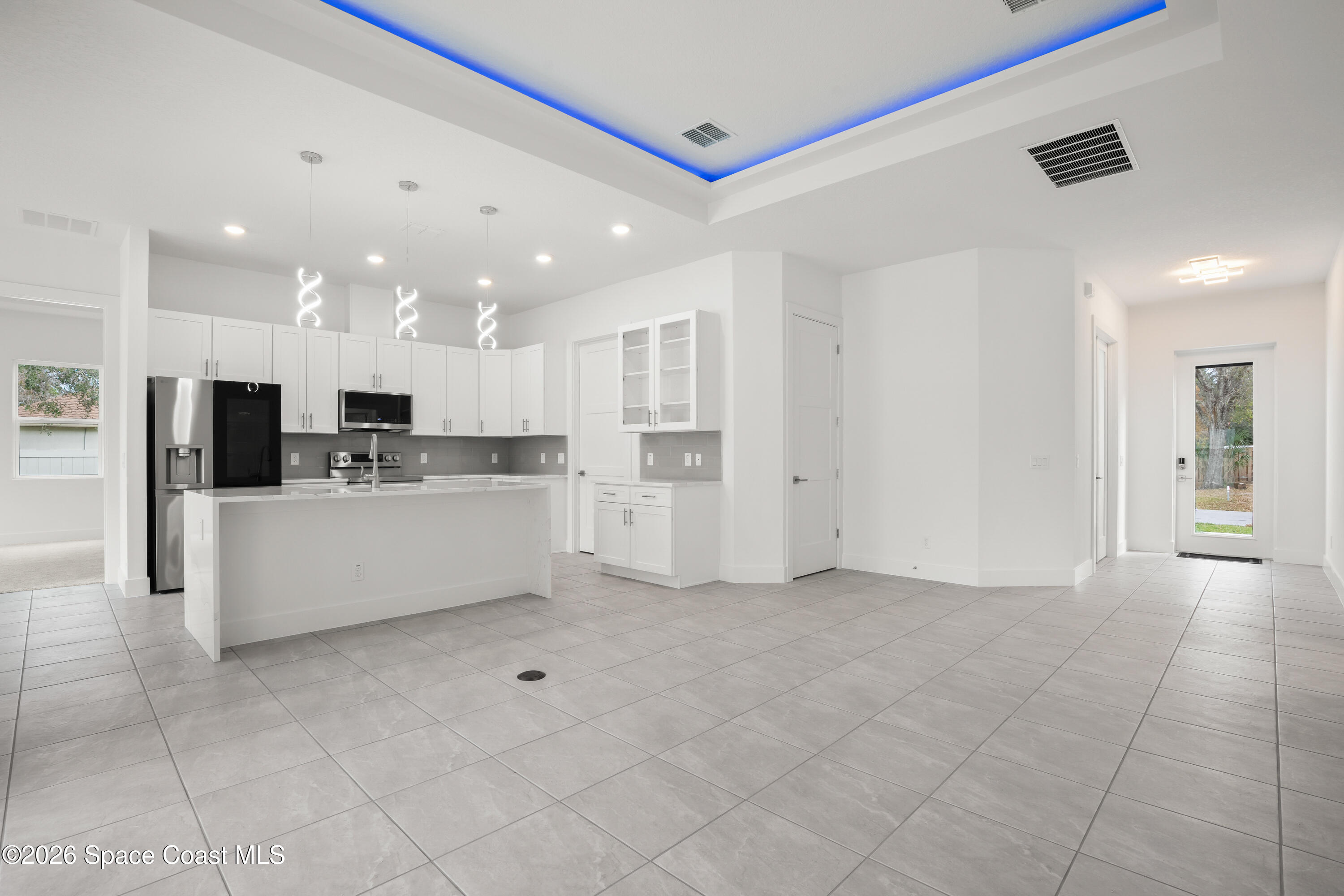 655 Vine Street Melbourne, FL 32904 - Photo 11 of 33 a large white kitchen with kitchen island white cabinets and stainless steel appliances