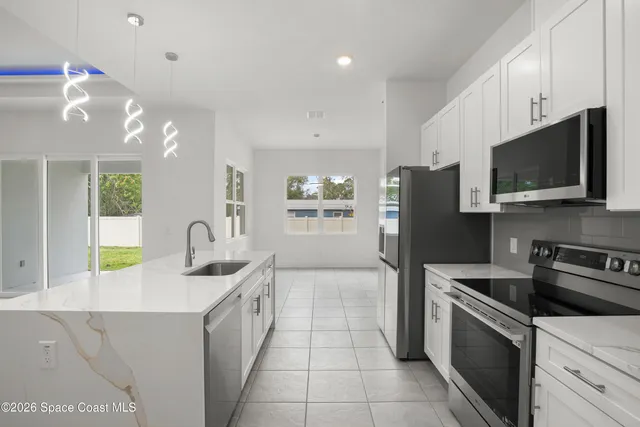 a kitchen with stainless steel appliances a stove sink microwave and refrigerator
