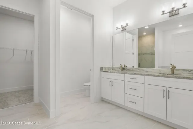 a bathroom with a granite countertop sink mirror and toilet