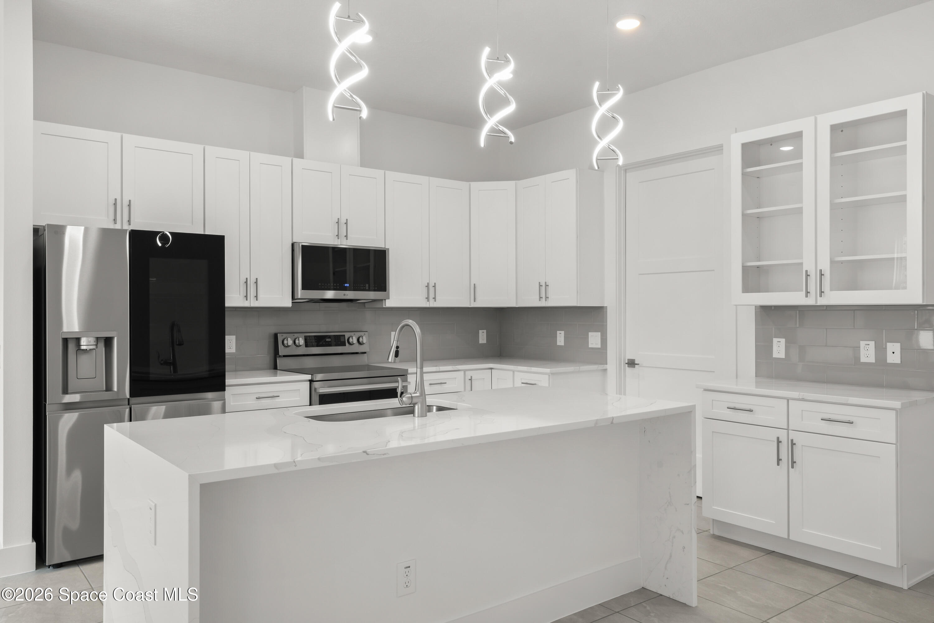 655 Vine Street Melbourne, FL 32904 - Photo 8 of 33 a kitchen with white cabinets and stainless steel appliances
