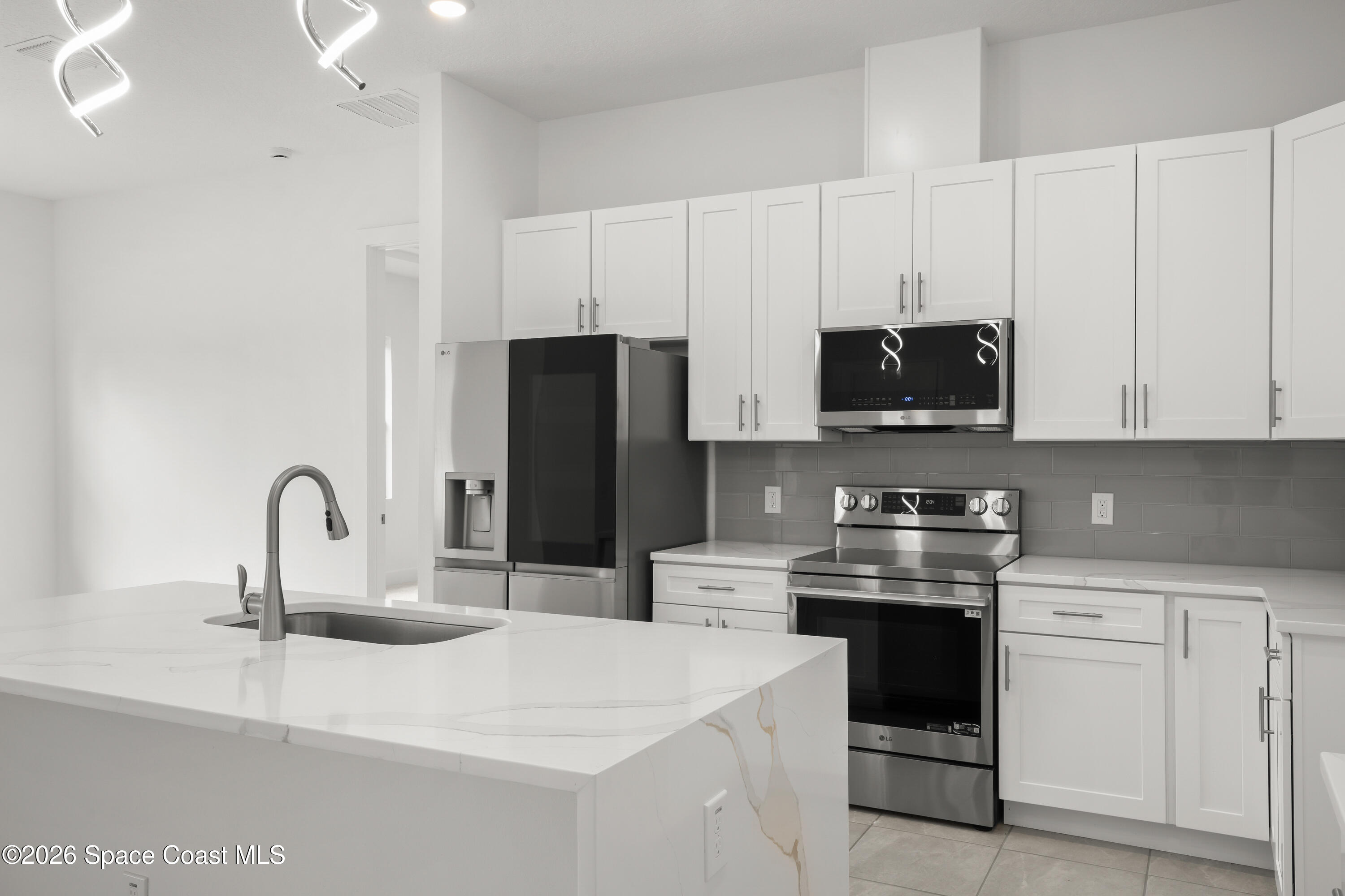 655 Vine Street Melbourne, FL 32904 - Photo 9 of 33 a kitchen with stainless steel appliances kitchen island a white stove top oven and white cabinets