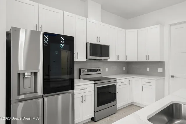 a kitchen with stainless steel appliances white cabinets and a refrigerator