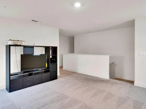 a living room with flat screen tv and gym equipment