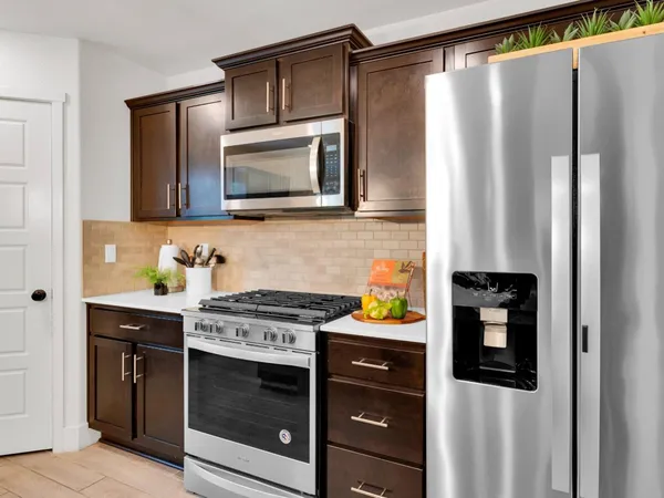 a kitchen with stainless steel appliances granite countertop a refrigerator and a stove top oven
