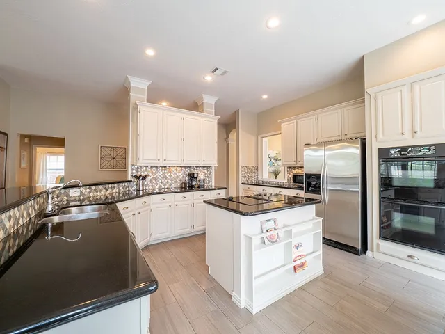 a kitchen with white cabinets and stainless steel appliances