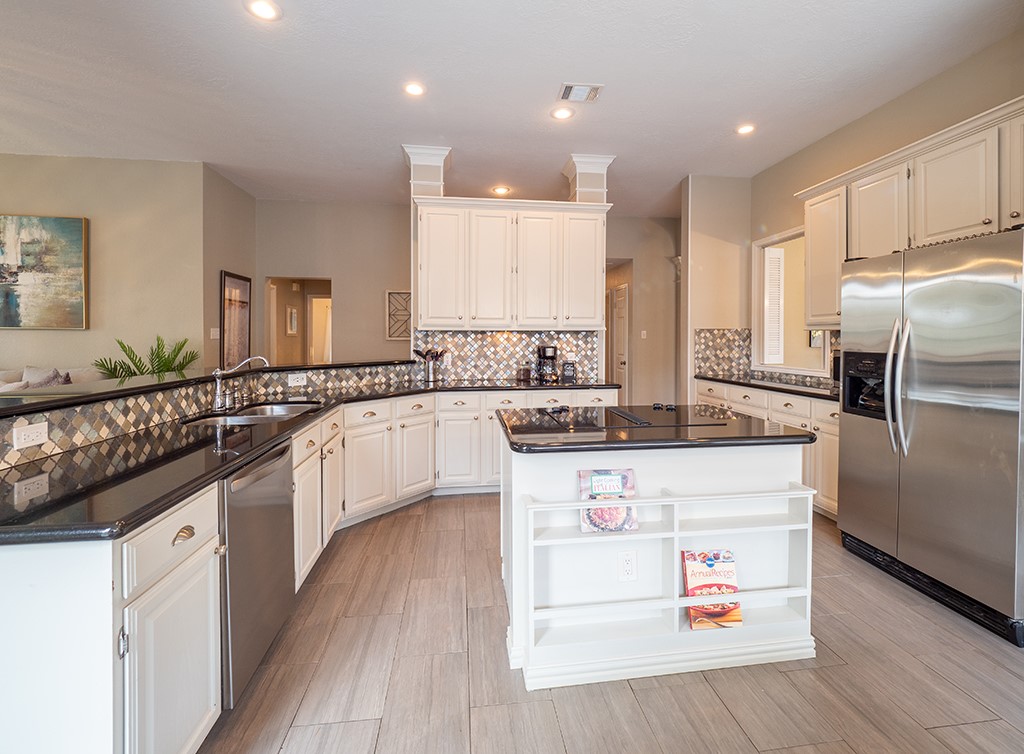 8007 Isaac Pryor Drive Austin, TX 78749 - Photo 12 of 38 a kitchen with stainless steel appliances granite countertop a sink a stove a refrigerator and island with wooden floor