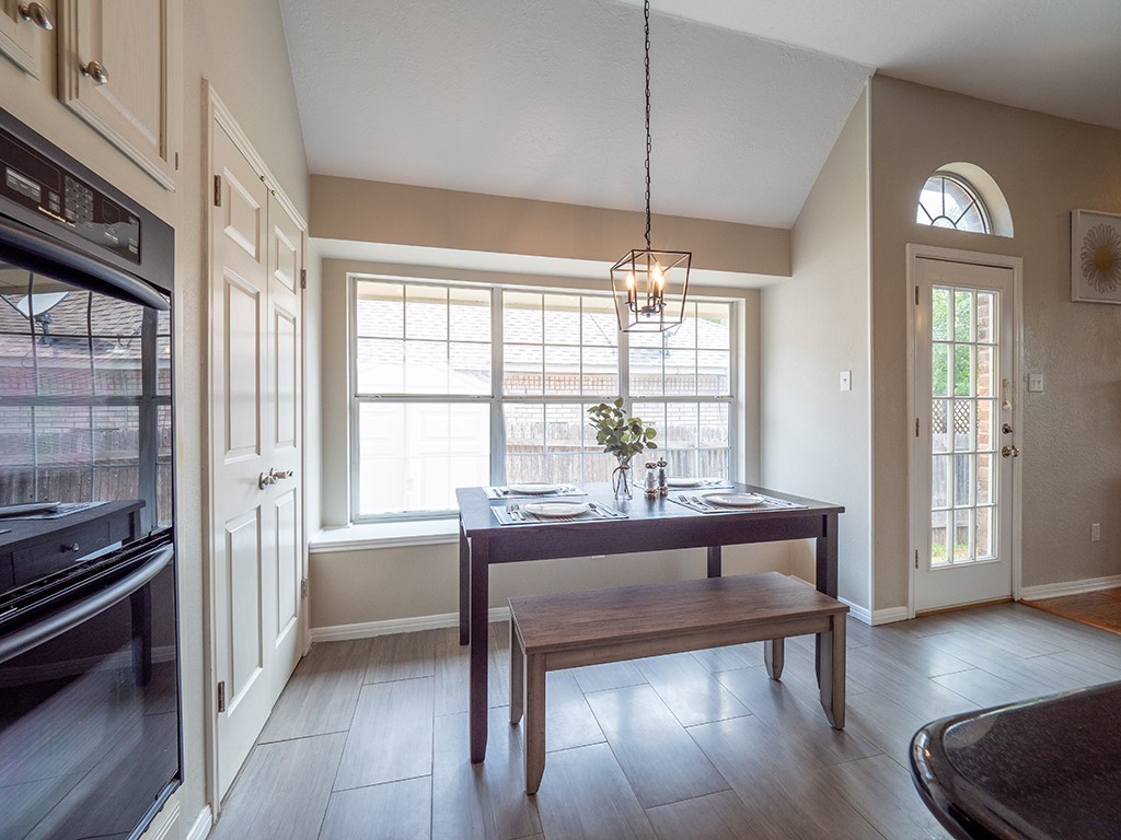 8007 Isaac Pryor Drive Austin, TX 78749 - Photo 15 of 38 a dining room with wooden floor a chandelier a wooden table and chairs
