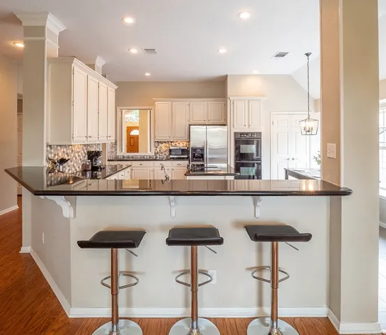 a kitchen with stainless steel appliances granite countertop a counter top space a sink refrigerator and cabinets