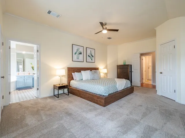 a spacious bedroom with a bed and a chandelier