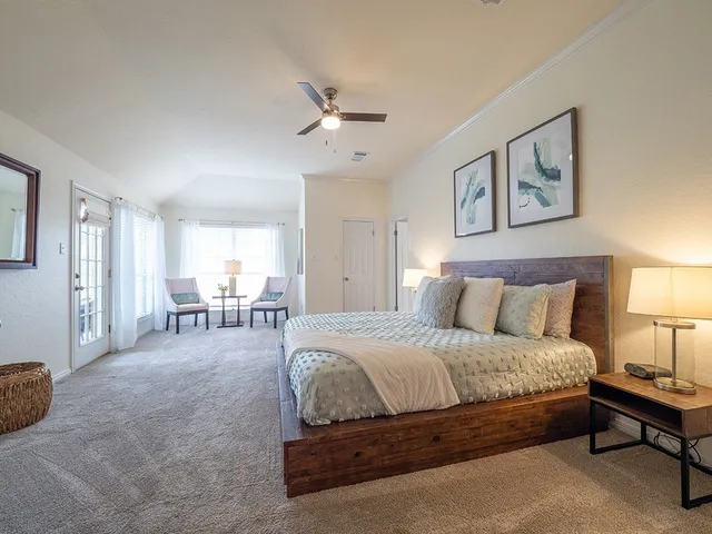 a spacious bedroom with a bed a couch and a window