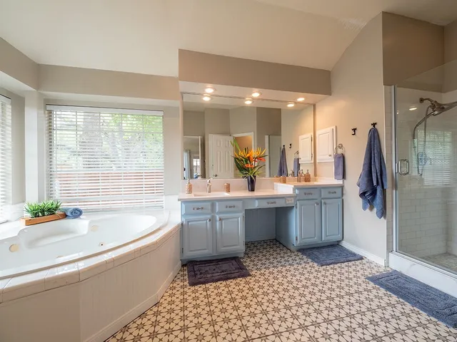 a bathroom with a bathtub a sink a mirror and a shower