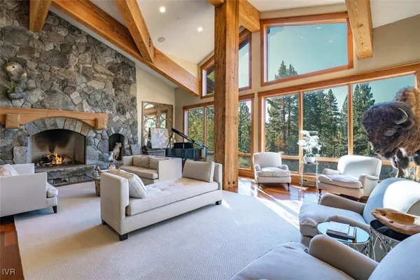 a living room with furniture a fireplace and large windows