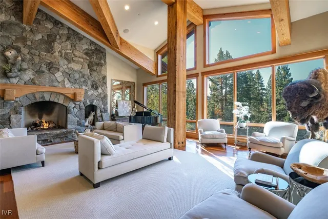 a living room with furniture a fireplace and large windows