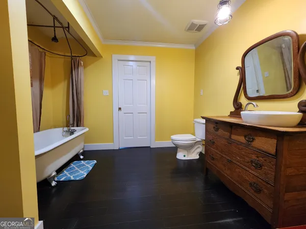 a bathroom with a toilet sink mirror and vanity