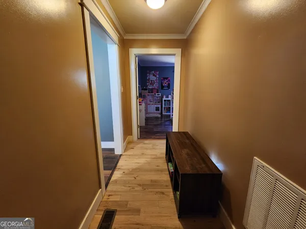 a view of a hallway with wooden floor and staircase