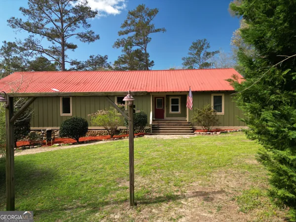 a view of a house with a yard patio and fire pit