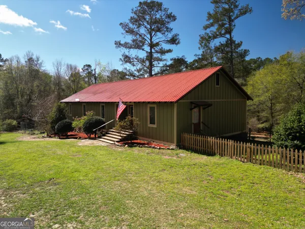 a view of a house with backyard and sitting area