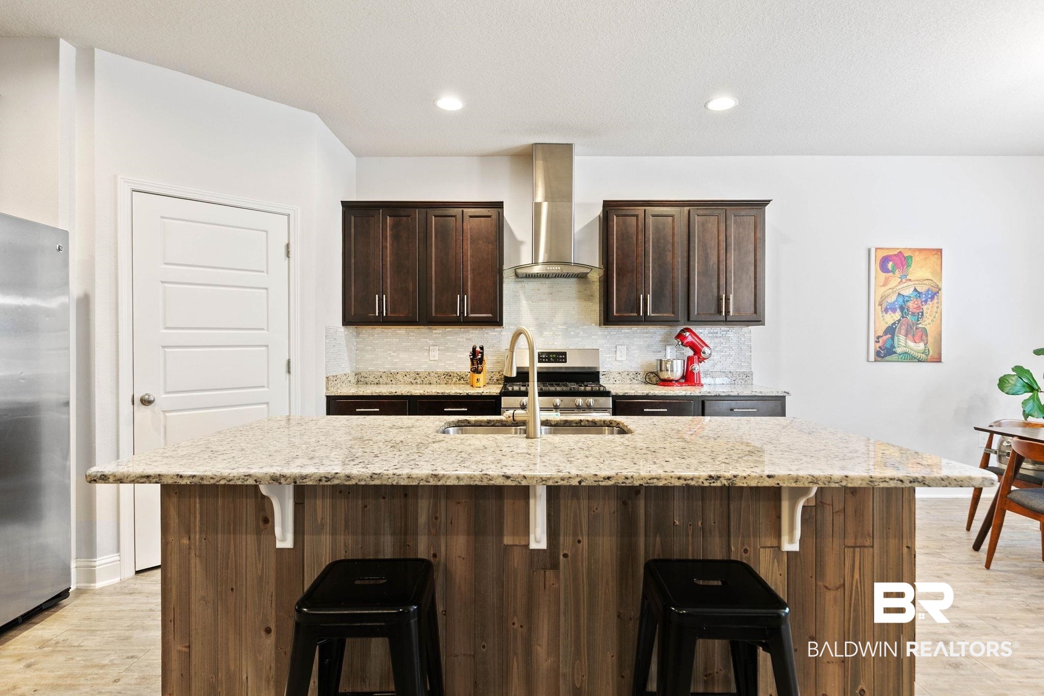 31350 Hoot Owl Road Daphne, AL 36527 - Photo 13 of 94 Kitchen featuring dark wood finish cabinets, light wood-style floors, light stone countertops, and recessed lighting