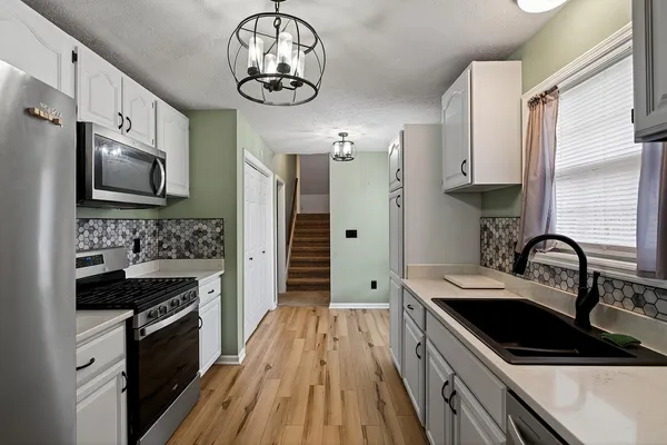a kitchen with stainless steel appliances a sink stove and refrigerator