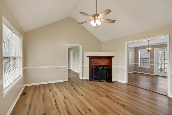 an empty room with wooden floor and windows